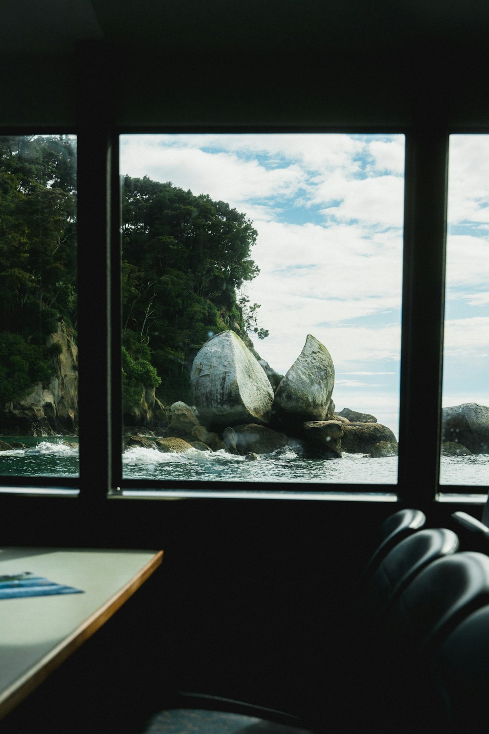 a room with a view of the water and rocks