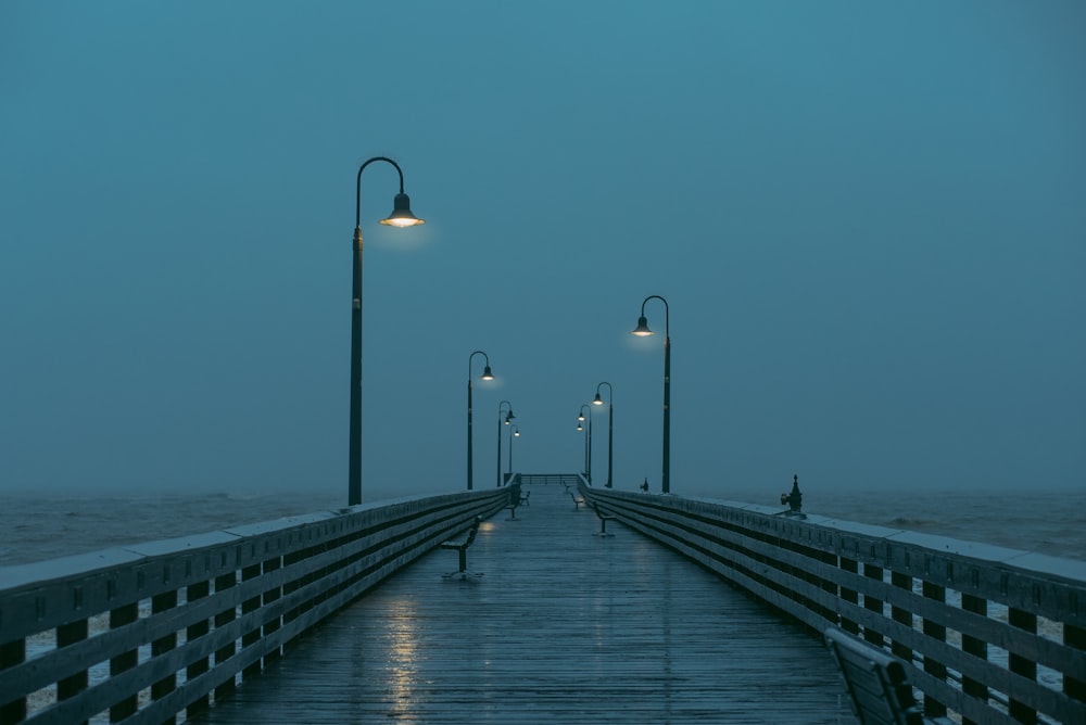 Ein Pier in der Nacht mit Straßenlaternen darauf