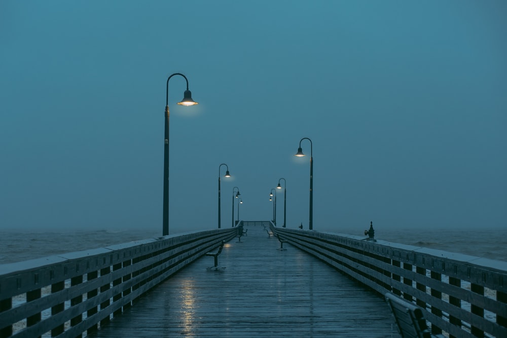 a pier at night with street lights on it