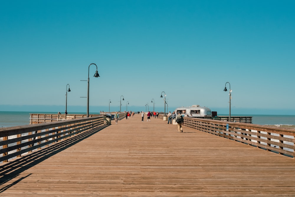 a wooden pier with people walking on it