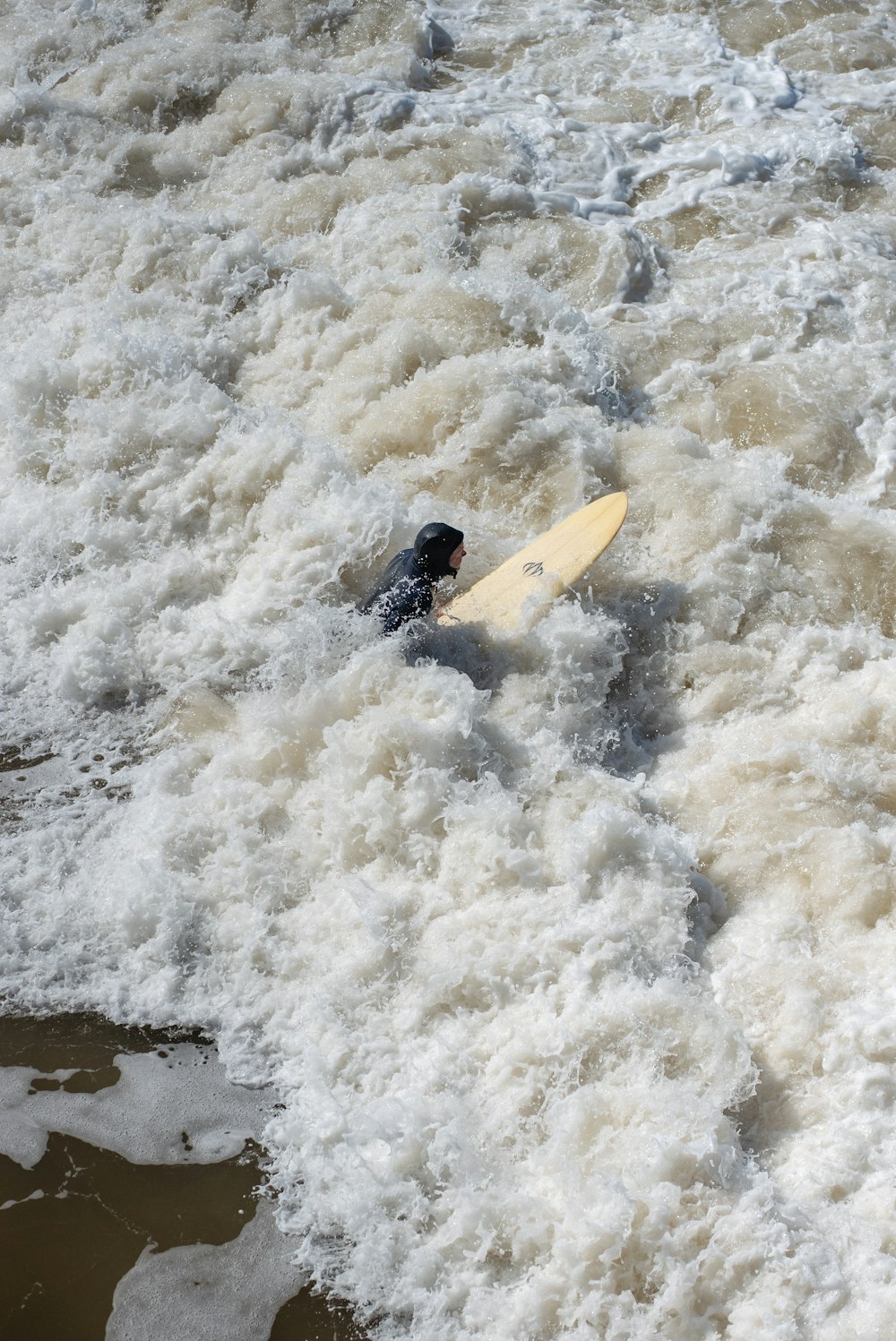 a person in a body of water with a surfboard