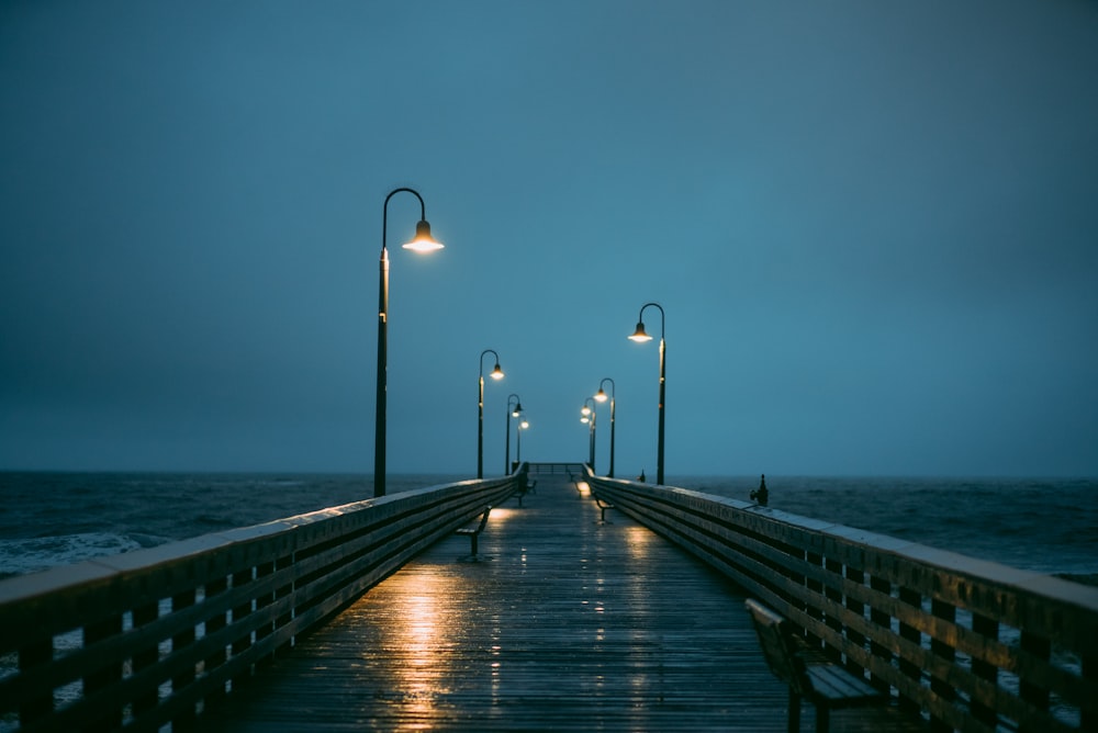 a pier at night with street lights on it