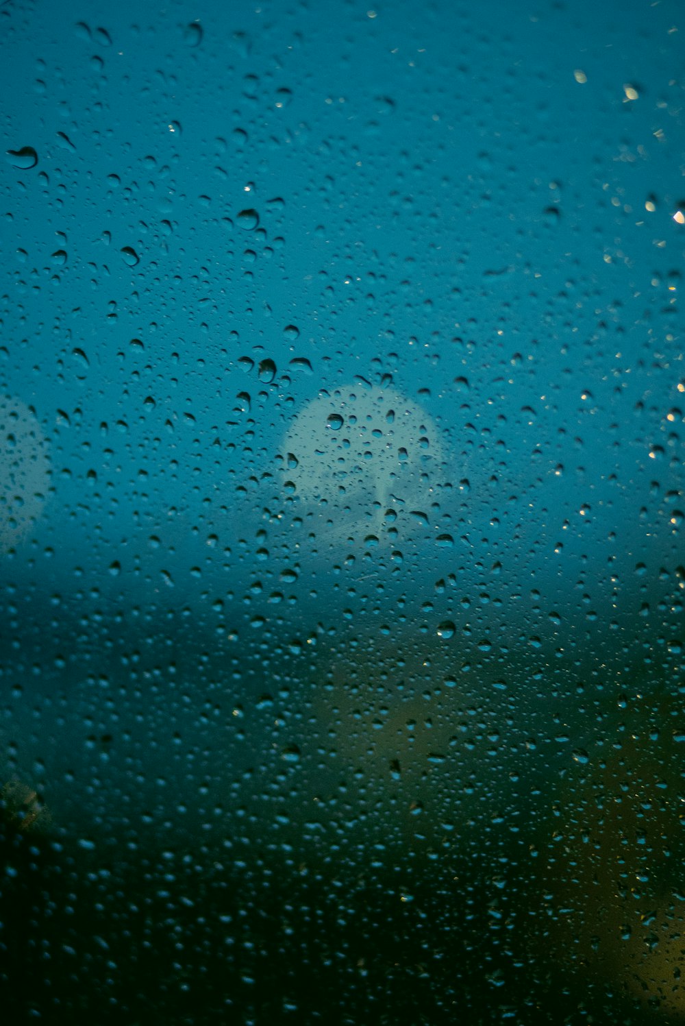 rain drops on a window with a blue sky in the background