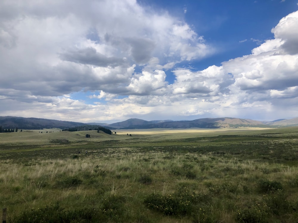 a wide open field with mountains in the distance