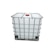 A large, white industrial container, often referred to as an Intermediate Bulk Container (IBC), is enclosed in a metal cage for support and stability. The container features a red cap on the top.