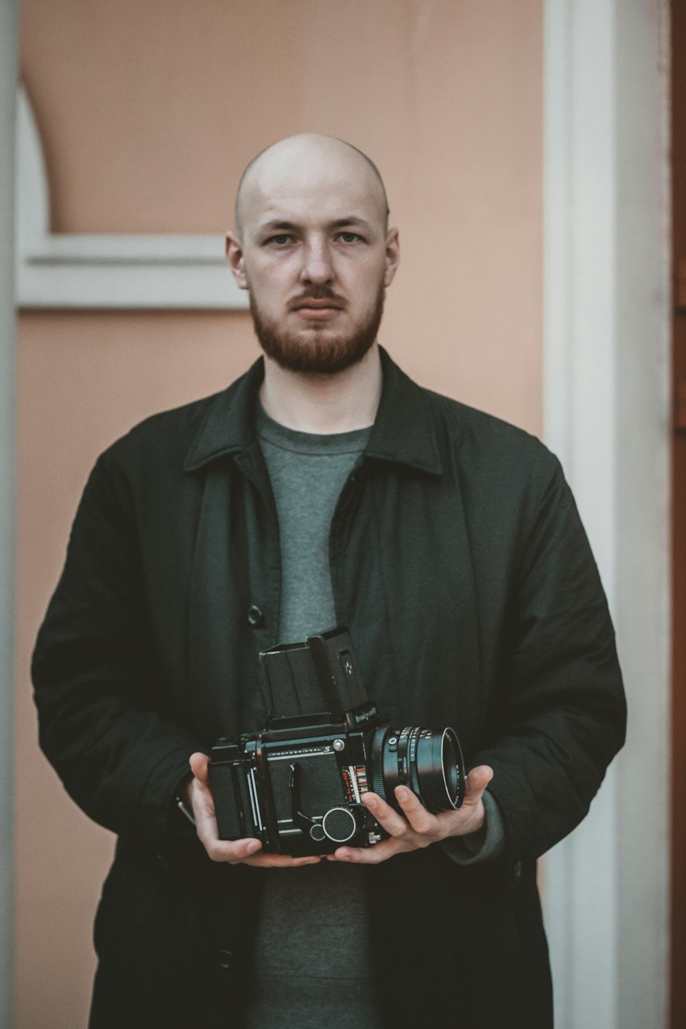 a man with a bald head holding a camera