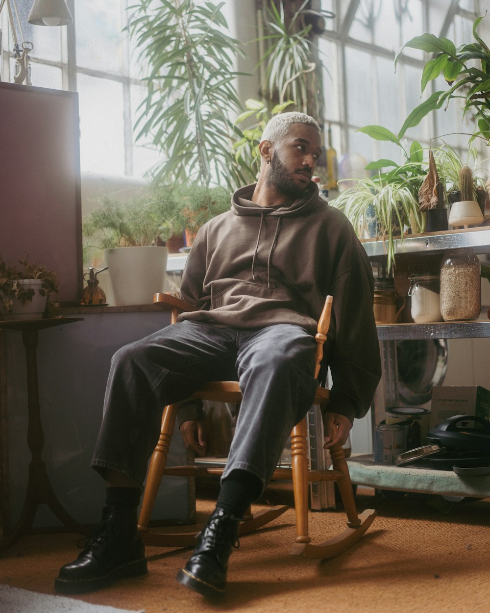 a man sitting in a rocking chair in front of a window