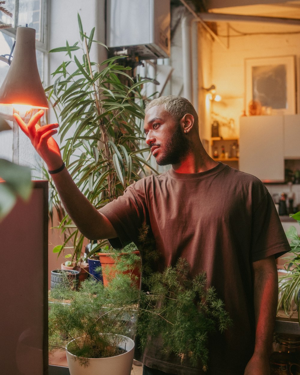 a man holding up a plant in a pot