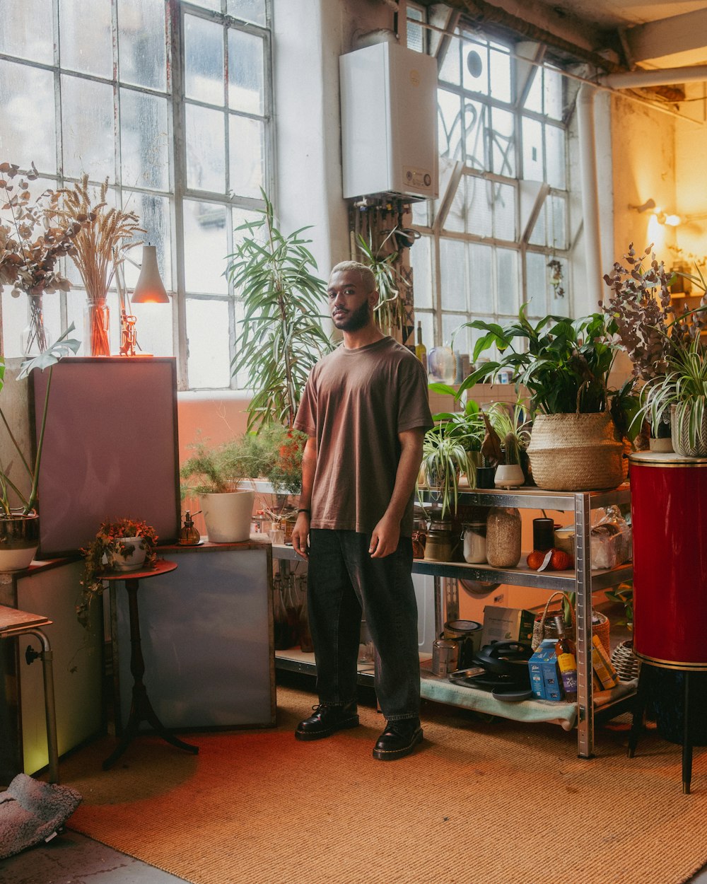 a man standing in a room full of plants