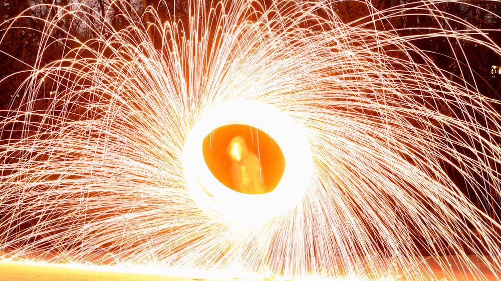 a large orange object is in the middle of a firework display