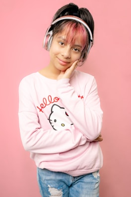 Kate smiling while wearing headphones in front of a soundboard.