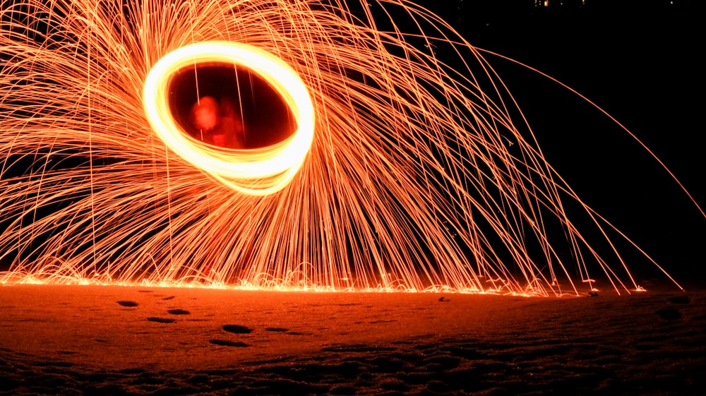 a person is spinning a circular object with fire