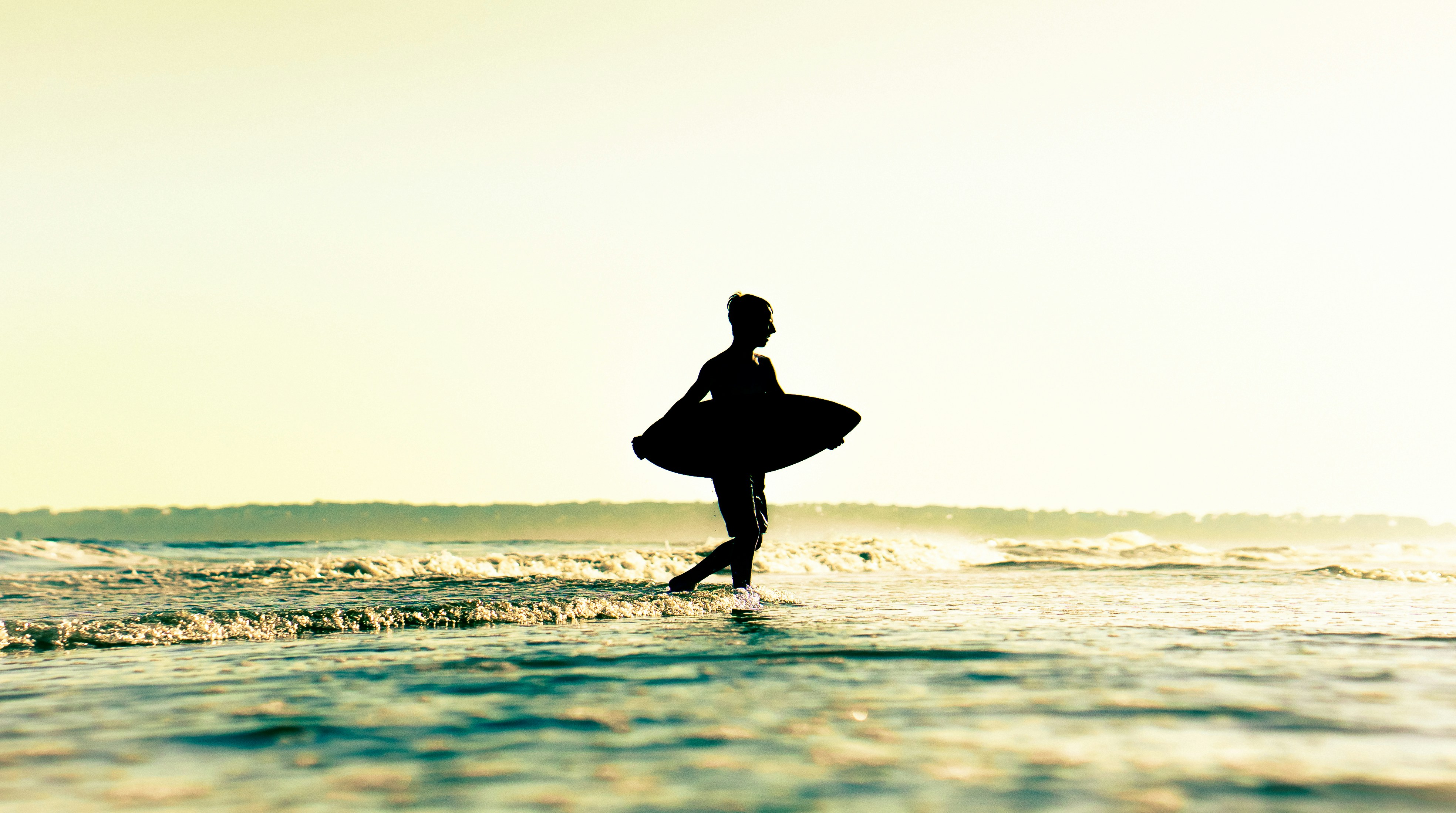 a person standing in the water with a surfboard