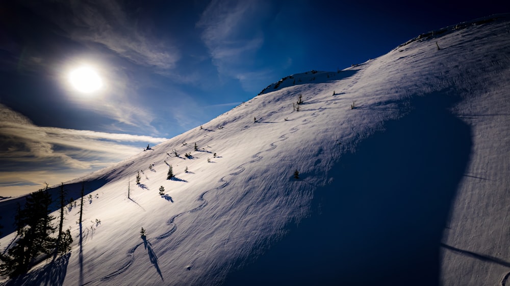 the sun is shining over a snowy mountain