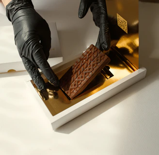 A delivery person handing over a beautifully wrapped box of chocolates in a cozy home setting.