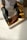 Hands carefully packaging a luxury product with white, gold, and black accents.