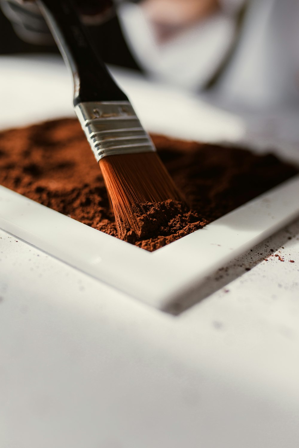a spatula of cocoa powder and cocoa powder on a plate