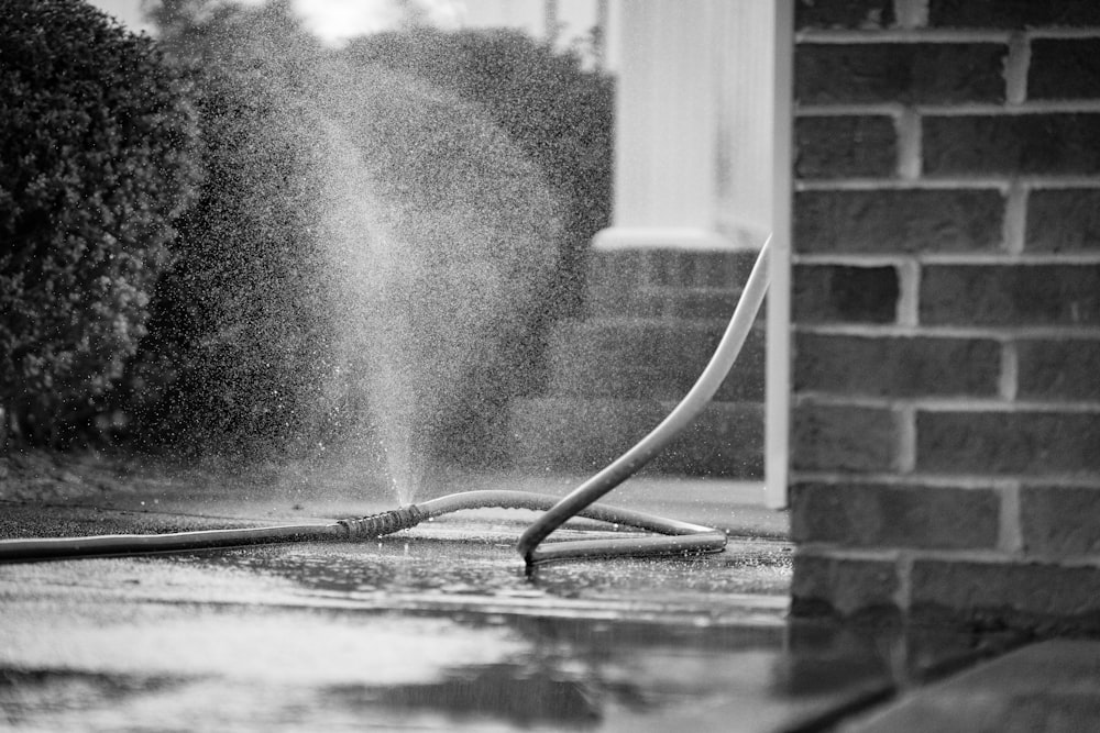 a fire hydrant spewing water onto a sidewalk