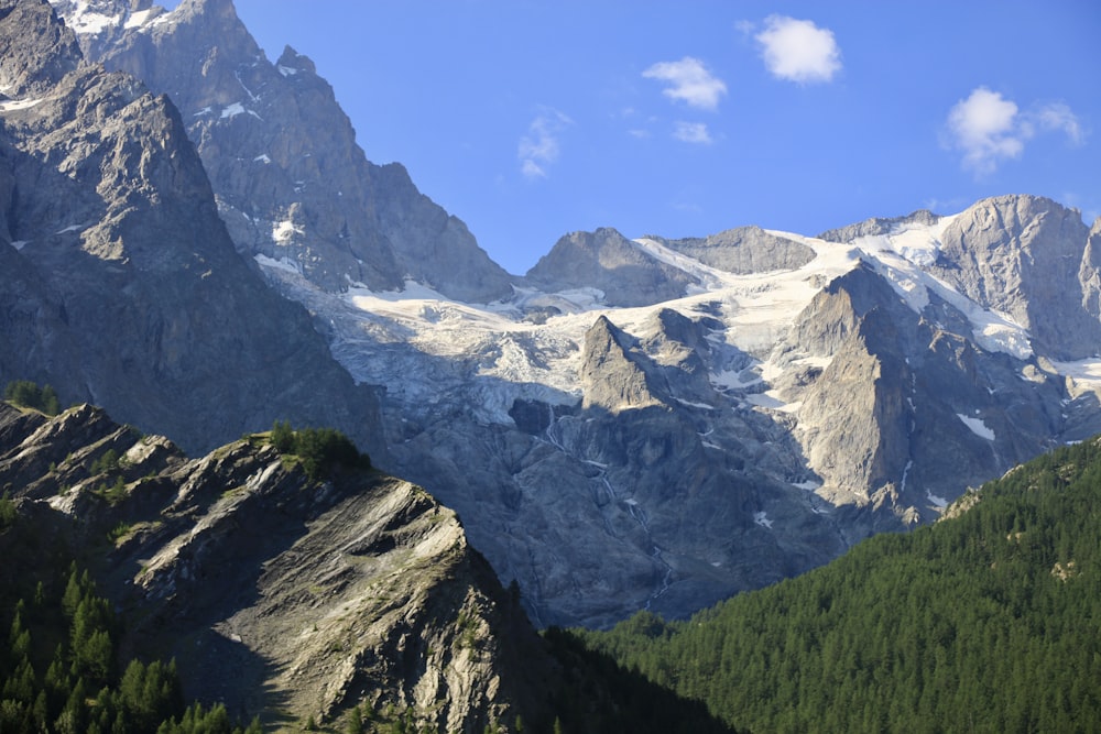 a view of a mountain range with trees in the foreground