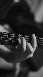 a person playing a guitar with their hands