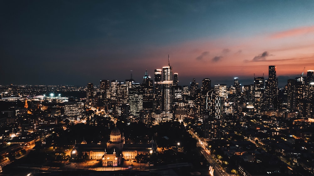 Una vista de una ciudad por la noche desde la cima de una colina