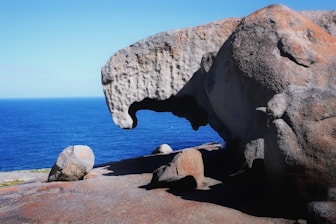a large rock formation with a large body of water in the background