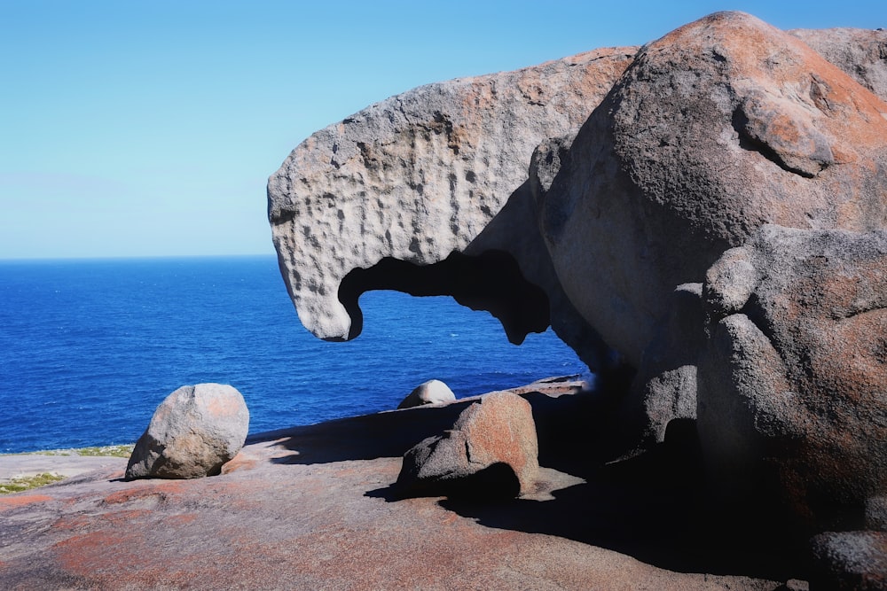 a large rock formation with a large body of water in the background