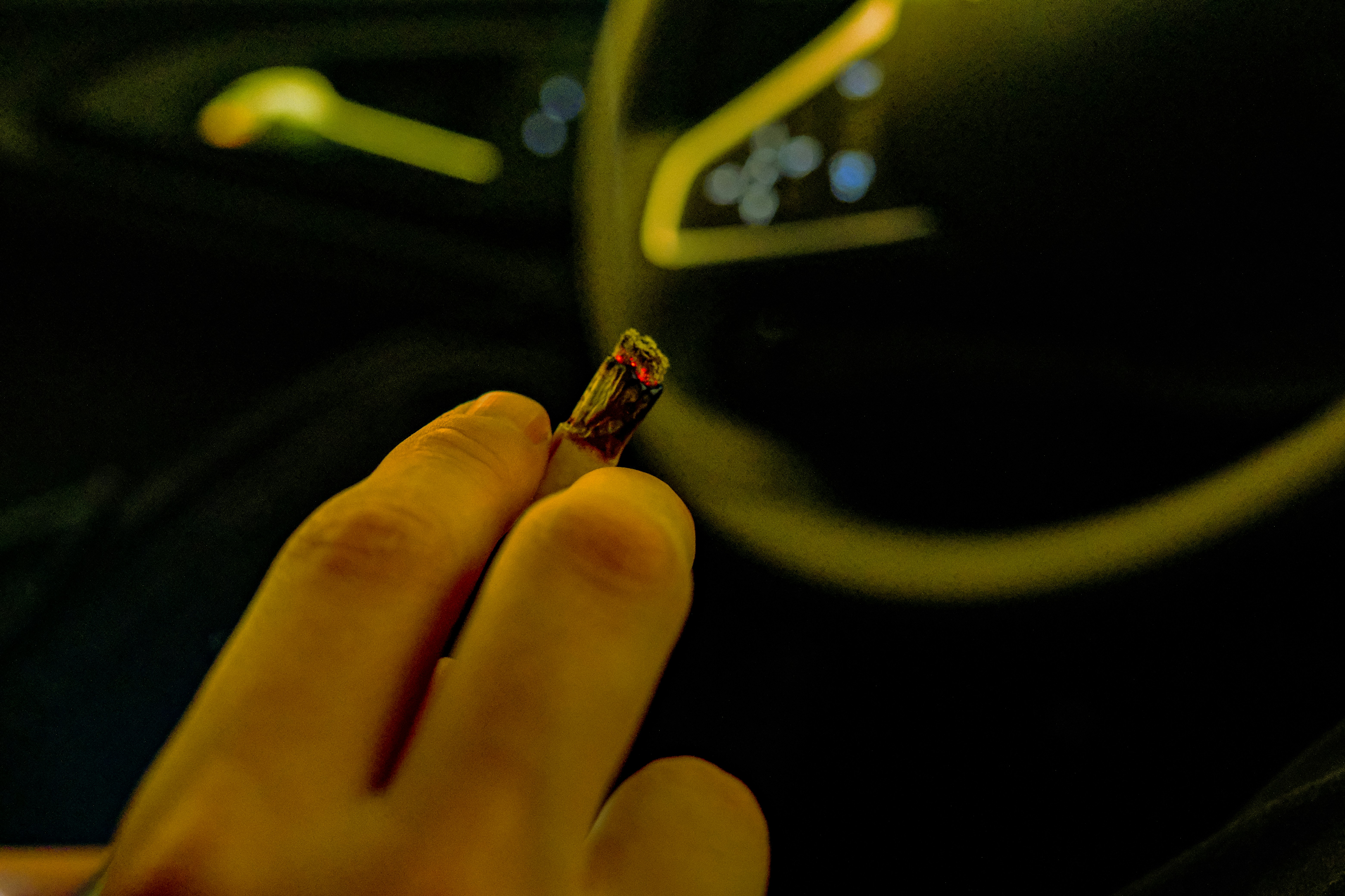 a person holding a cigarette in their hand