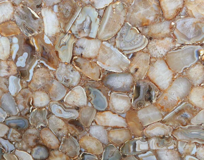 Close-up of polished natural agate stones with rich earthy tones displayed on a wooden surface.