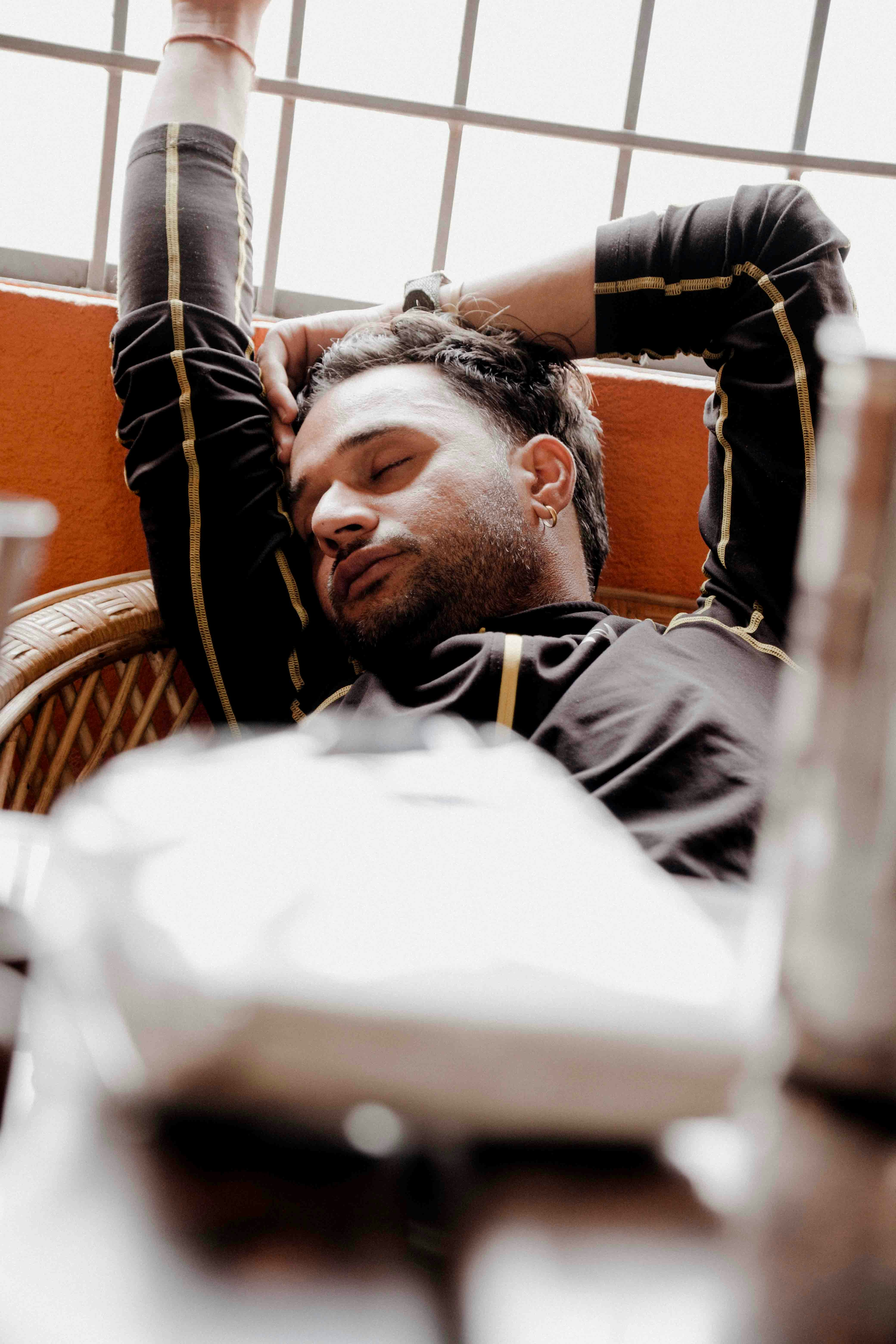 a man sitting in a chair with his hand on his head