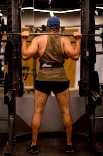 Back support worn by a fitness enthusiast lifting weights in a gym.