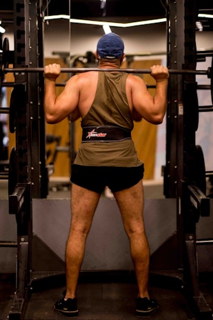 Back support worn by a fitness enthusiast lifting weights in a gym.