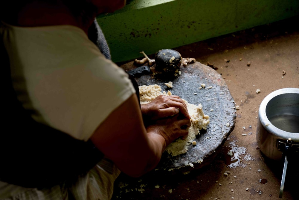 a person is kneading dough on a table