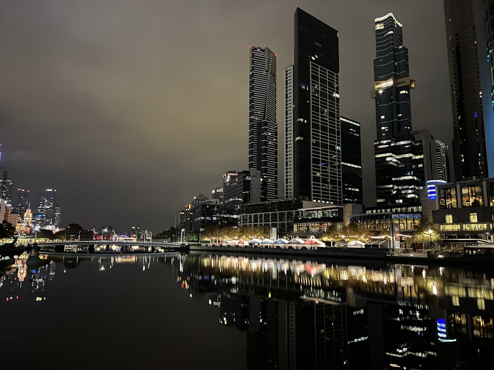 a body of water in front of a city at night