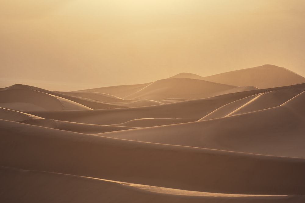 the sun is shining over the sand dunes