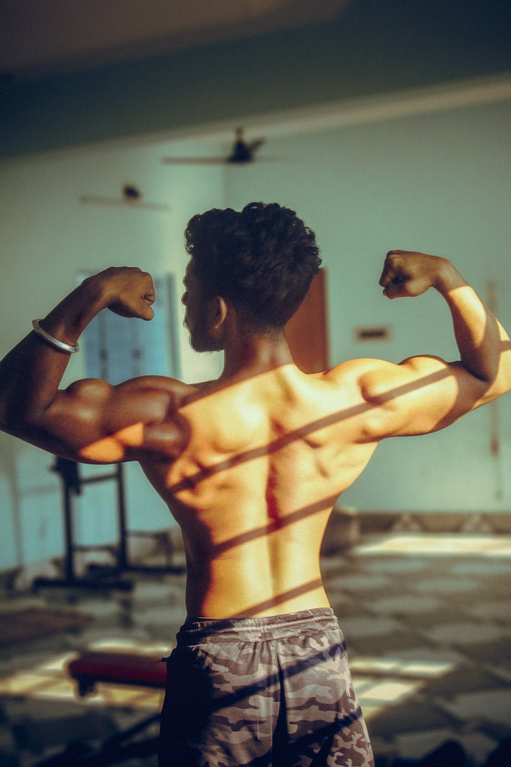 a man flexing his muscles in a gym