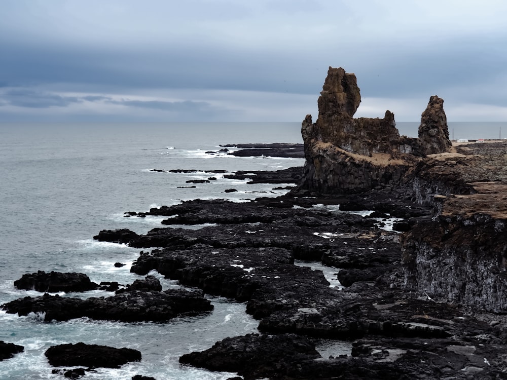 a large body of water next to a rocky shore