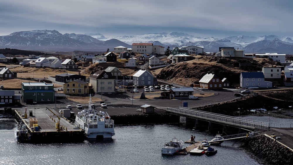 a harbor filled with lots of boats next to snow covered mountains