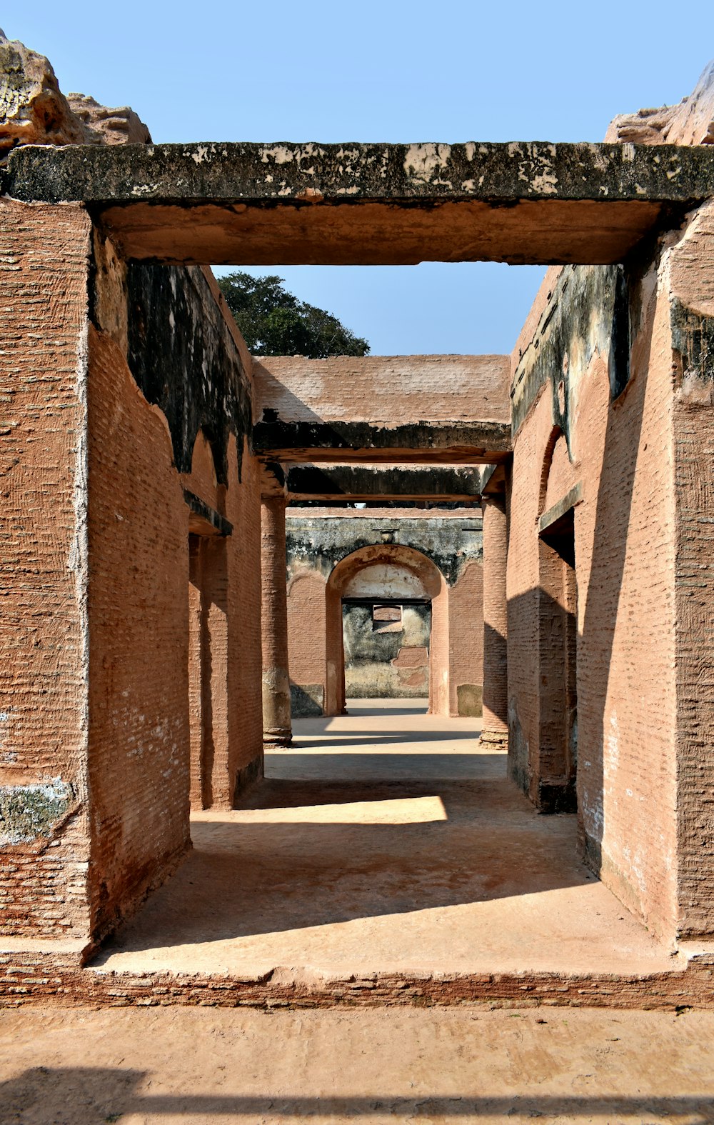 a stone archway in a brick building with a blue sky in the background