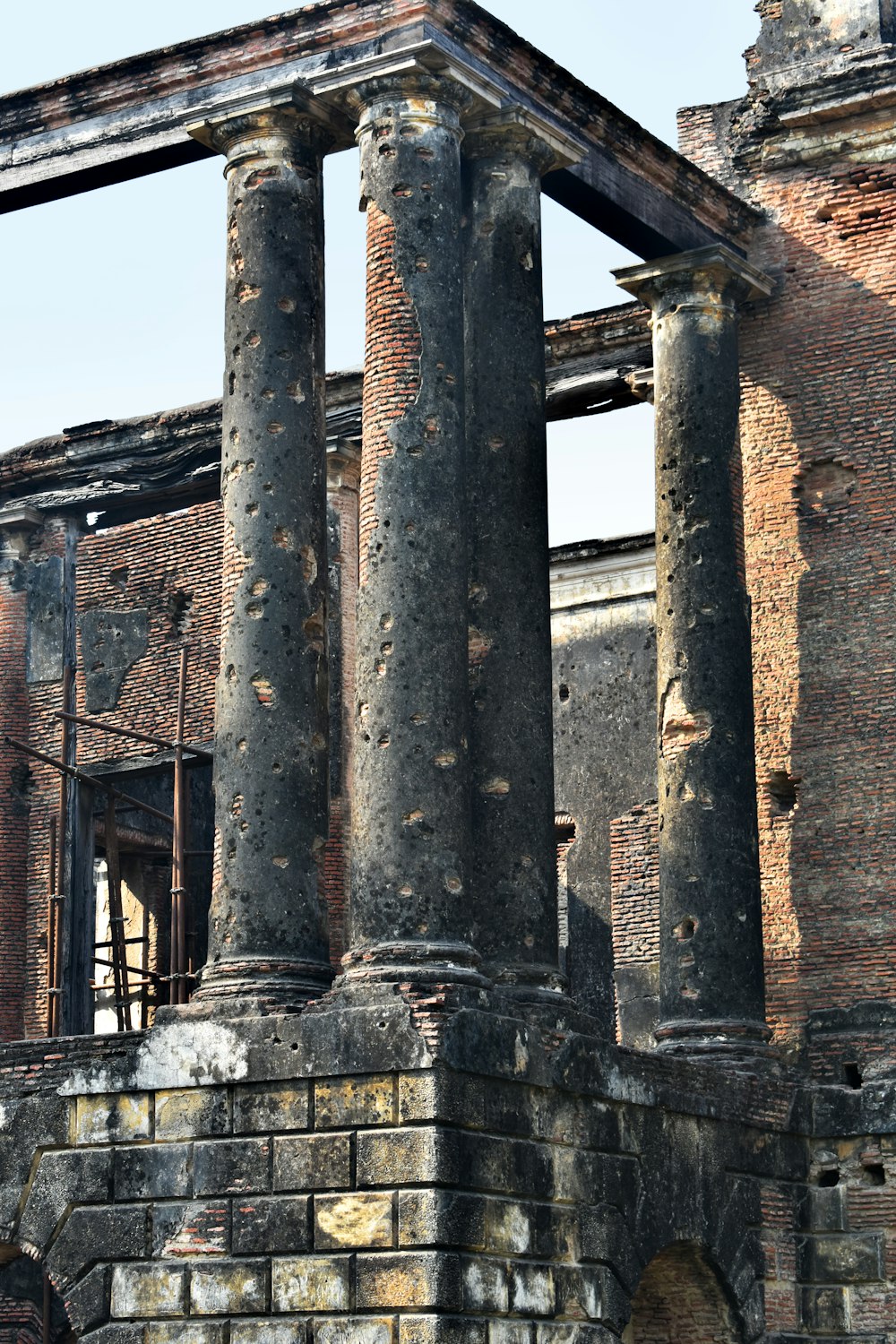 an old brick building with columns and a clock