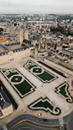 an aerial view of a large building with a green lawn in the middle of it