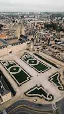 an aerial view of a large building with a green lawn in the middle of it
