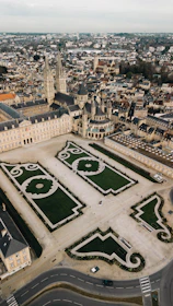 an aerial view of a large building with a green lawn in the middle of it