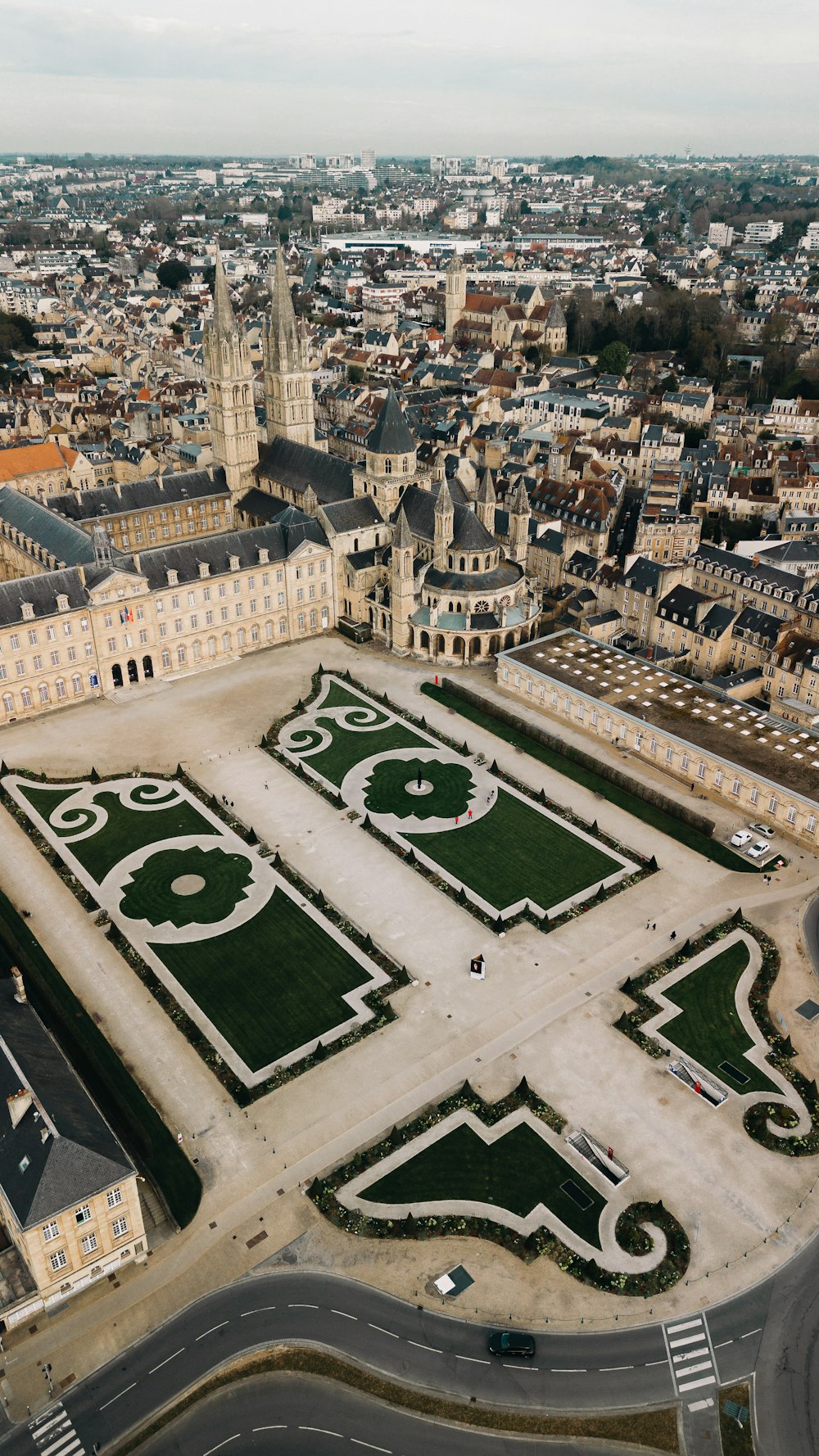 an aerial view of a large building with a green lawn in the middle of it