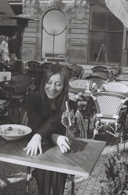 A woman smiling while enjoying a healthy meal outdoors.