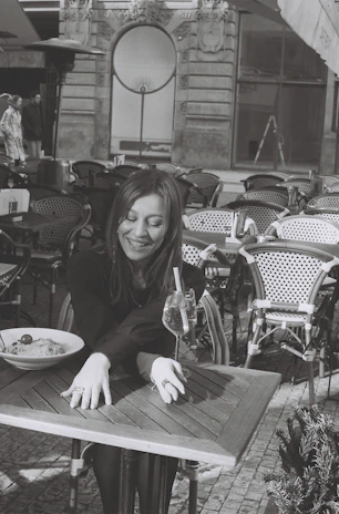 A smiling woman enjoying a healthy meal outdoors, symbolizing wellness and vitality.