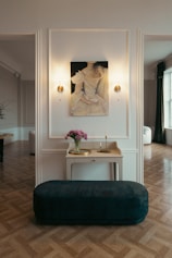 Elegant triple room with soft pastel colors and a small seating area.