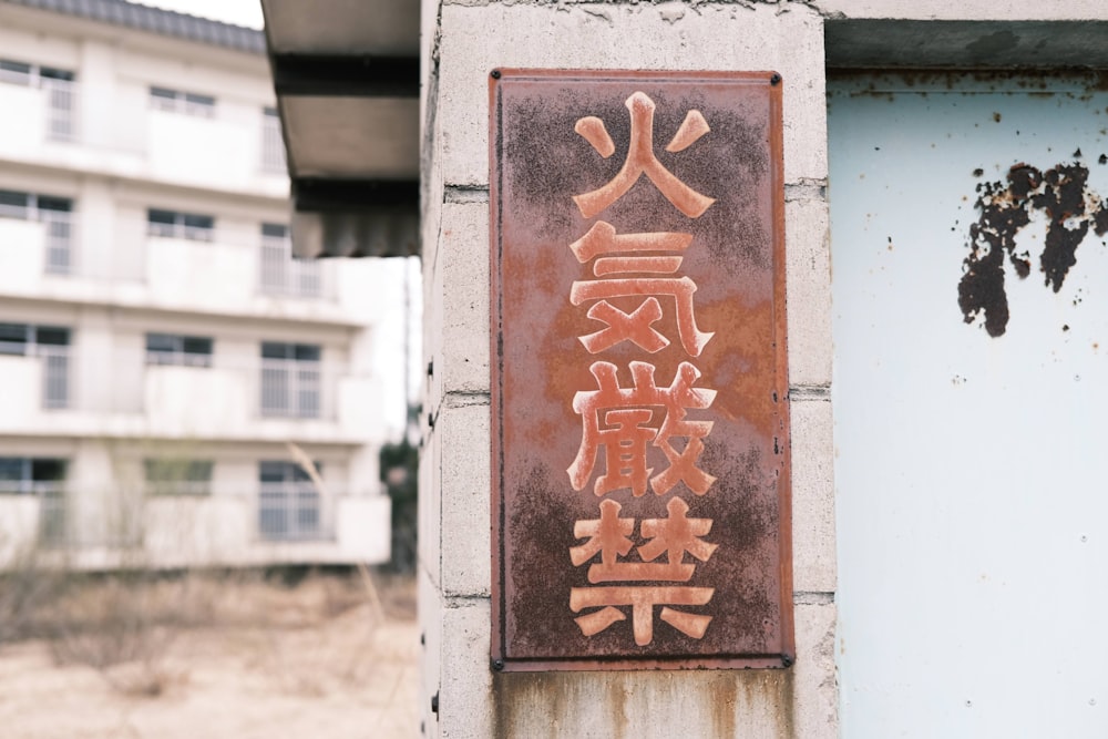 a rusted metal sign on the side of a building