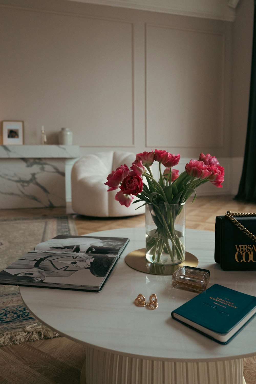 Un tavolo con un vaso di fiori e un libro su di esso foto