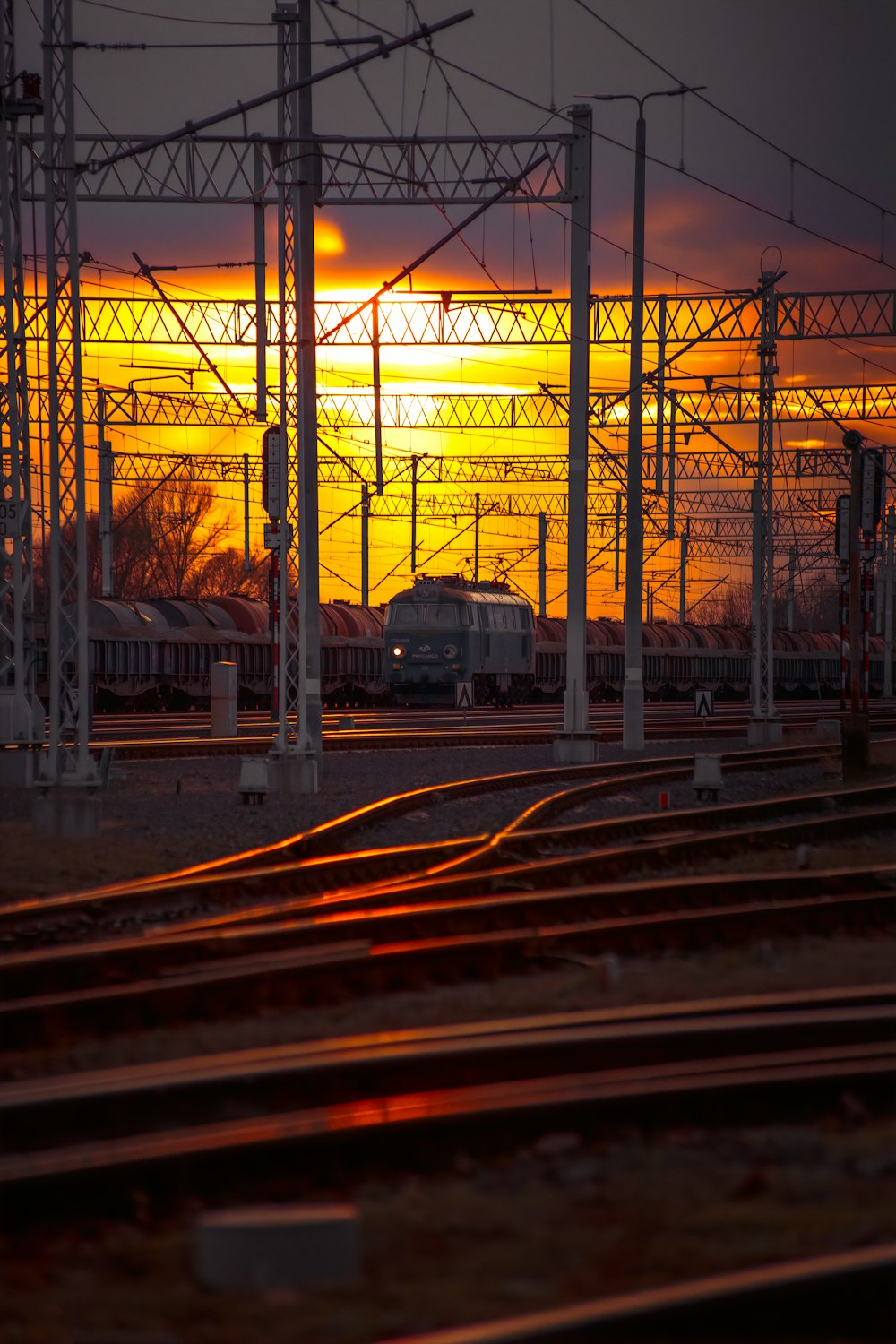 the sun is setting over a train yard